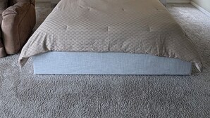 Une chambre à coucher avec un grand lit, deux tables de chevet, une chaise et un ventilateur de plafond.