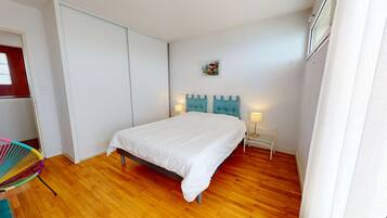 Une chambre à coucher comprenant un lit, une table de chevet, une chaise et une armoire.