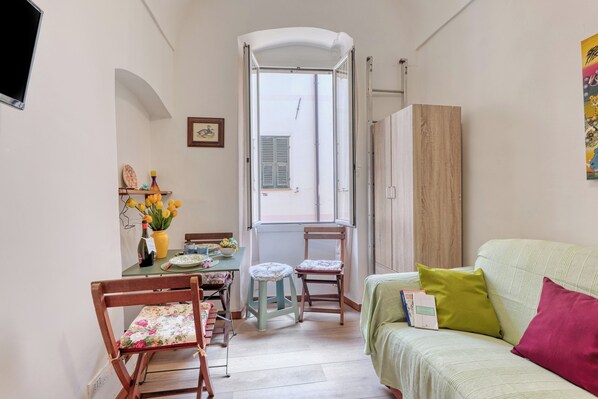 Habitación compacta con una mesa de comedor, sillas, un sofá y un ventanal con vistas.