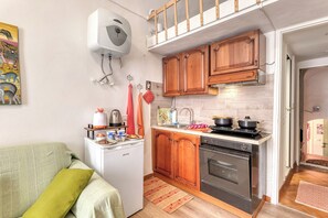 Una cocina compacta con armarios de madera, horno empotrado y refrigerador.