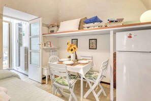 Una cocina funcional con mesa, sillas, refrigerador y radiador.