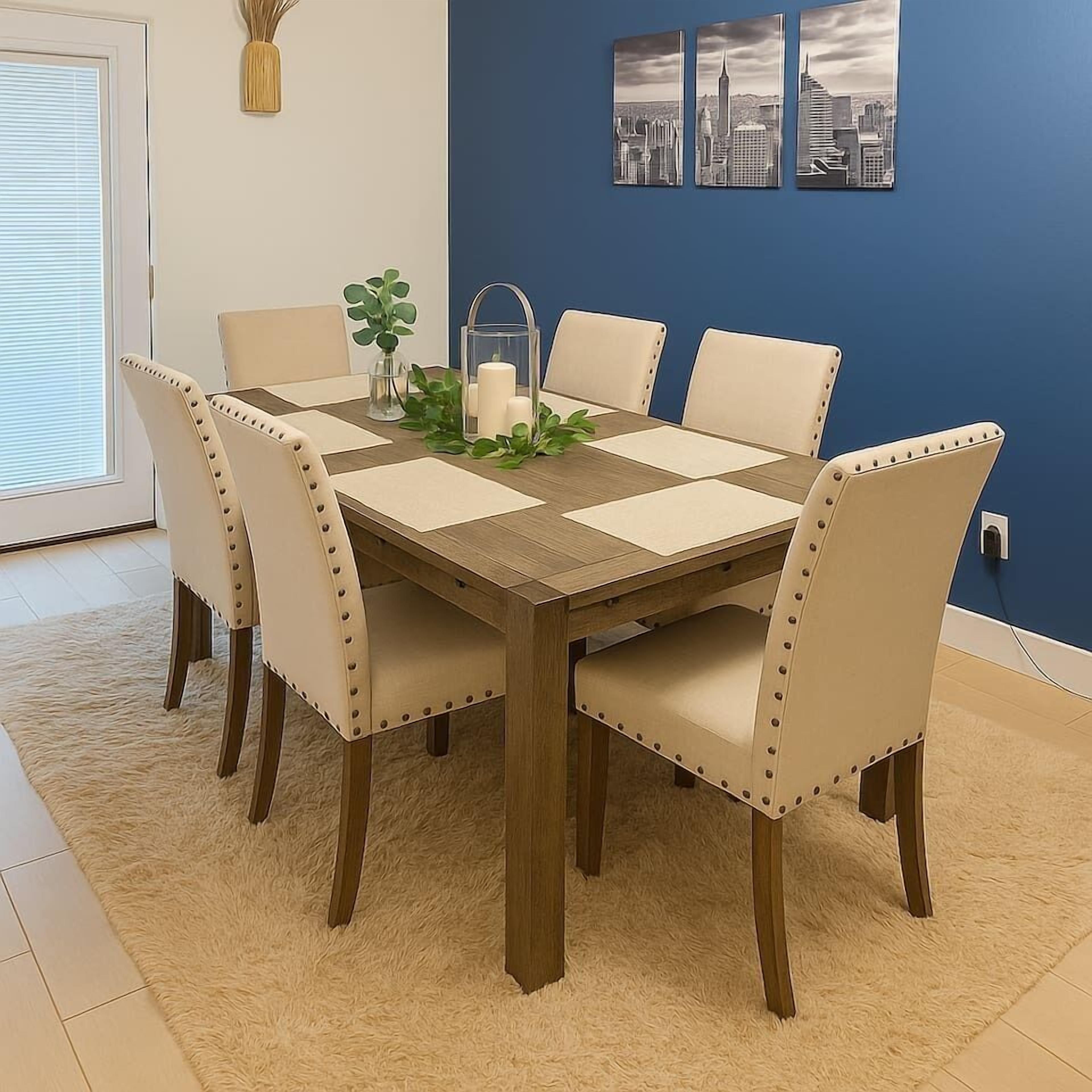 Un tavolo da pranzo con sei sedie, un vaso con verdeggianti elementi decorativi e un candelabro.