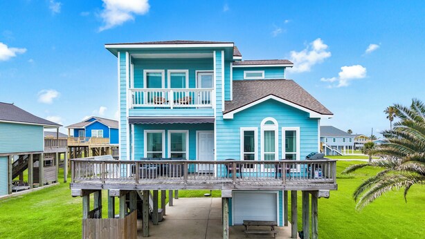 A two-story house with a balcony, a covered porch, and a small deck. - Palms & Pelicans - recently updated, a block from the beach (Galveston)