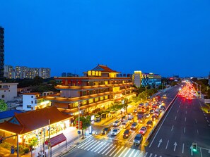 A multi-story hotel with traditional architecture, located at a busy intersection with heavy traffic. - Shengyu Hotel (Dongguan)