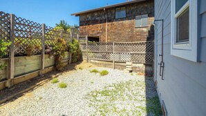 Il s'agit d'une propriété résidentielle avec une façade en bois, une allée en gravier et une clôture en bois.