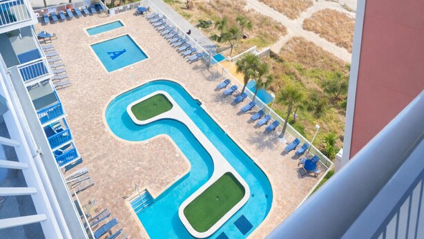 Un complexe hôtelier doté d’une piscine, d’une plage et offrant une vue sur l’océan.