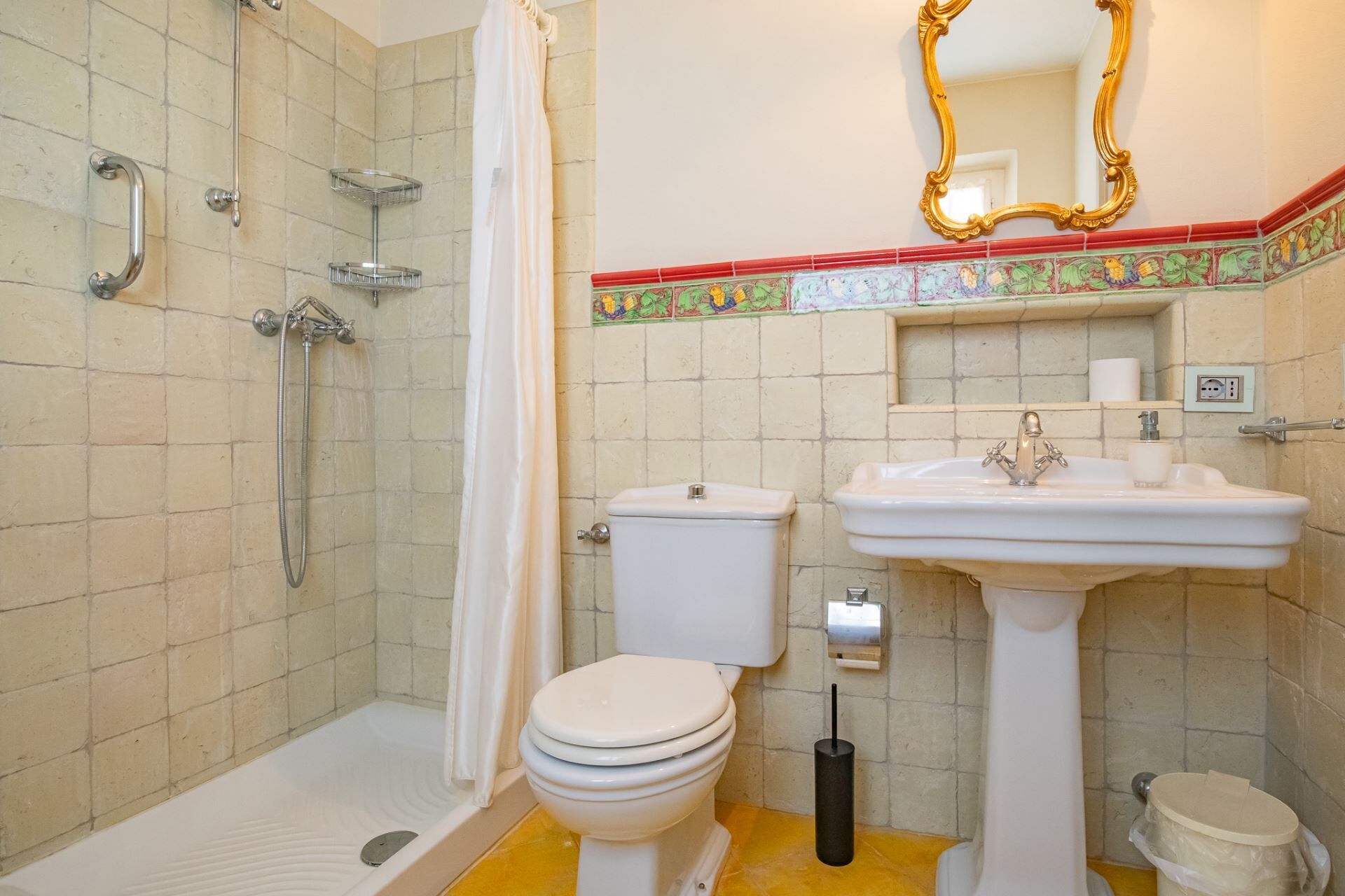 Un bagno con doccia, toilette, lavandino e specchio.
