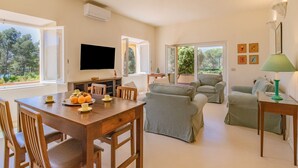 Un salón amplio con una mesa de comedor, sofás y televisor.