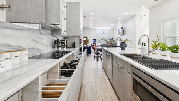 A modern kitchen with a marble countertop, built-in cabinets, and a central island. - Spacious Dallas 4 bedroom Game Room & Spa 3 (Dallas)
