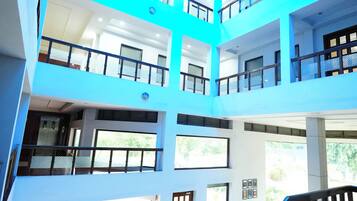 Un atrium à plusieurs niveaux, doté de rampes en verre et d’un escalier.