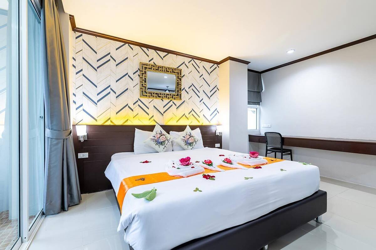 Quarto de hotel com uma cama grande, uma escrivaninha e uma cadeira.