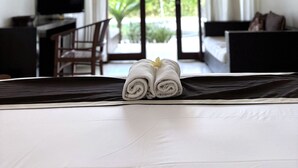 Habitación de hotel con cama, televisión, escritorio y vistas a zonas verdes.
