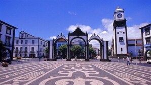 A plaza with ornate arches and a clock tower.