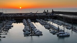 A marina with boats docked at the pier, a bridge, and a sunset in the background. - The Touline Apple **** (Fécamp)