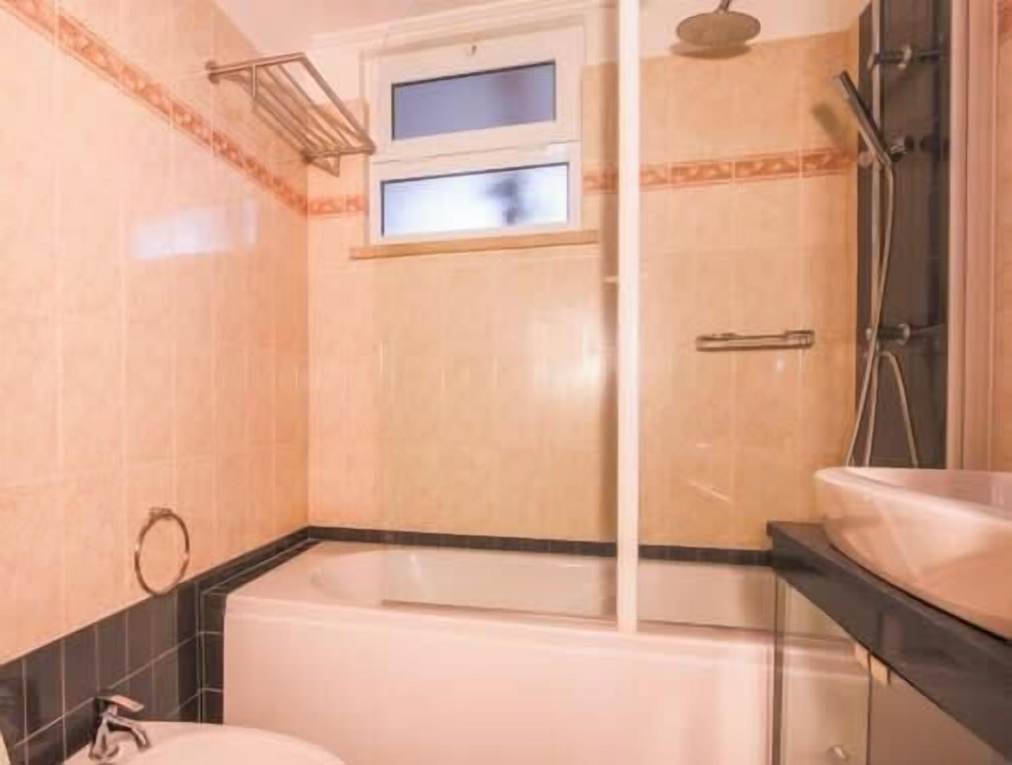 A bathroom with a bathtub, a shower, and a window.