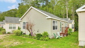 A single-story house with a front porch, a small deck, and a yard with grass and shrubs. - 1 Mi to Beach: Cottage w/ Pool Access in Wells (Wells)