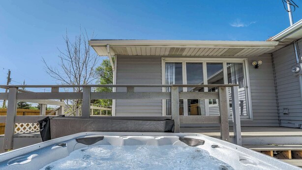 A hot tub on a wooden deck with a house in the background. - Parkside Estate! House & Cottage w/ 2 Hot Tubs (Monument)