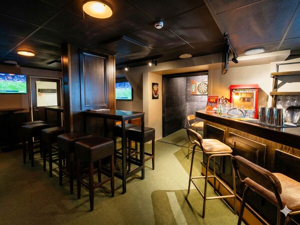 A bar area with stools, a dartboard, and a dartboard on the wall. - Hotelli Savonlinna (Savonlinna)
