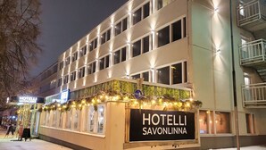 Un hotel con un cartel que dice "HOTELLI SAVONLINNA" y un símbolo de bicicleta que indica aparcamiento para bicicletas.