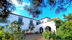 A white building with multiple windows and a covered walkway. - GuestReady - Quinta do Solar perfect for families (Ponta Delgada)