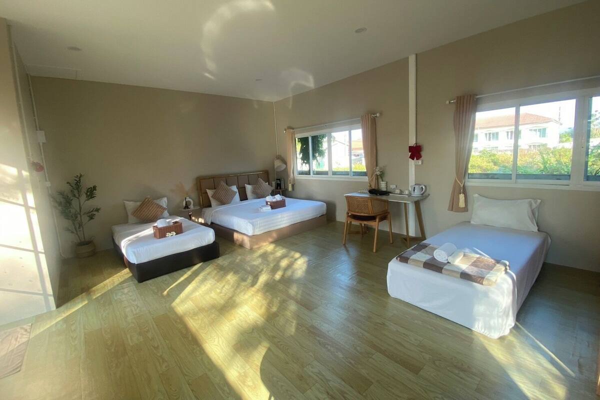 A hotel room with two beds, a desk, and a chair.