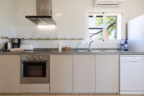 Een koffiezetapparaat/waterkoker, een koelkast, een oven, een vaatwasser