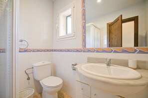 A bathroom with a toilet, sink, and shower.