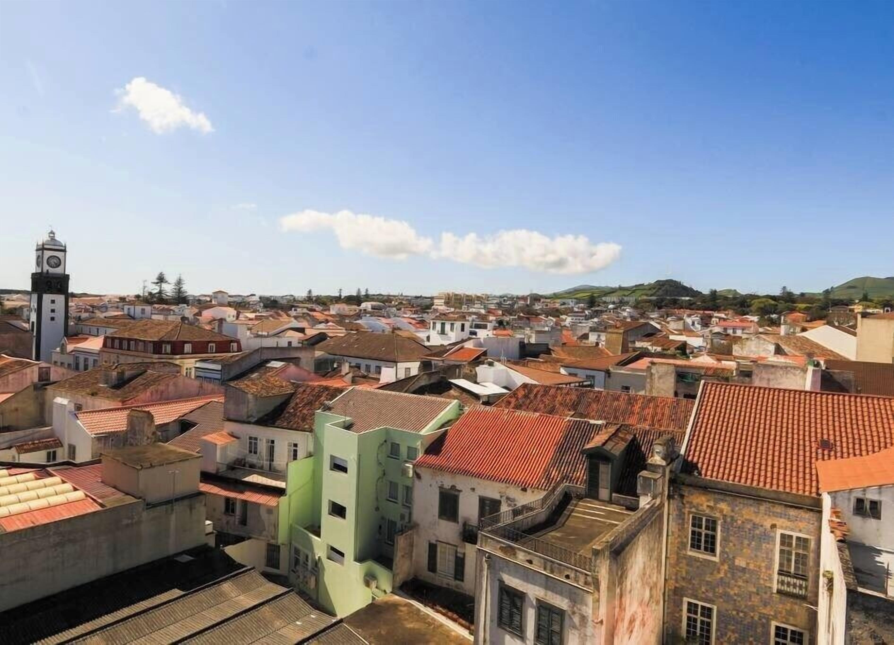 Une zone urbaine densément peuplée, où se côtoient des bâtiments traditionnels et modernes, et qui est notamment caractérisée par un imposant beffroi.