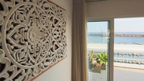 Quarto com um painel de parede grande e decorativo, e vista para a orla.