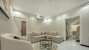 A modern living room with a sectional sofa, a round coffee table, and a chair.