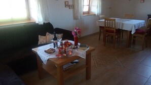 Una sala de estar acogedora con una mesa de madera dispuesta para comer, un sofá y una mesa de comedor con sillas.