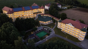 A large hotel with multiple balconies, a swimming pool, and solar panels.
