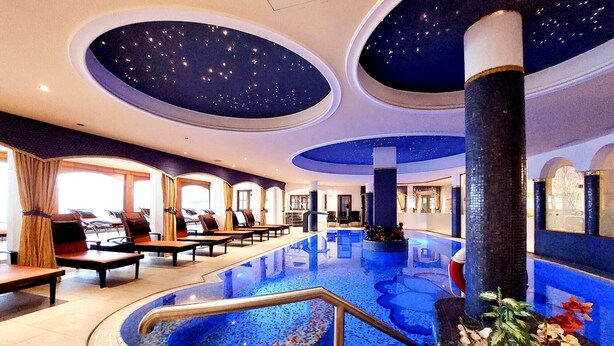 A hotel lobby with a large indoor pool, exercise area, and a ceiling with a starry design. - Parkschlössl zu Thyrnau (Thyrnau)