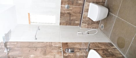 Un baño con ducha, inodoro y lavamanos.