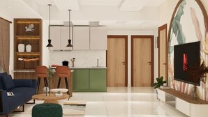 Una sala de estar moderna con sofá, mesa de centro y sillas. Cuenta con una zona de cocina con armarios y una mesa de comedor.