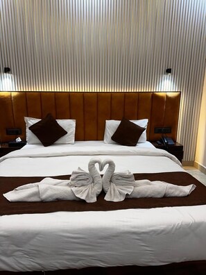 Ein Hotelzimmer mit einem großen Bett, zwei Nachttischen, einem Kopfteil und einer Wand mit vertikalen Linien.