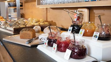 Ein Buffet mit verschiedenen Brotsorten, Gebäck und Marmeladen.