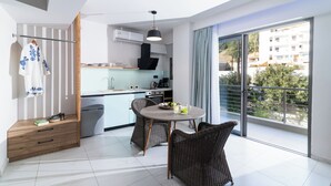 Une cuisine moderne avec un coin repas, un balcon offrant une vue agréable et un petit espace de rangement.