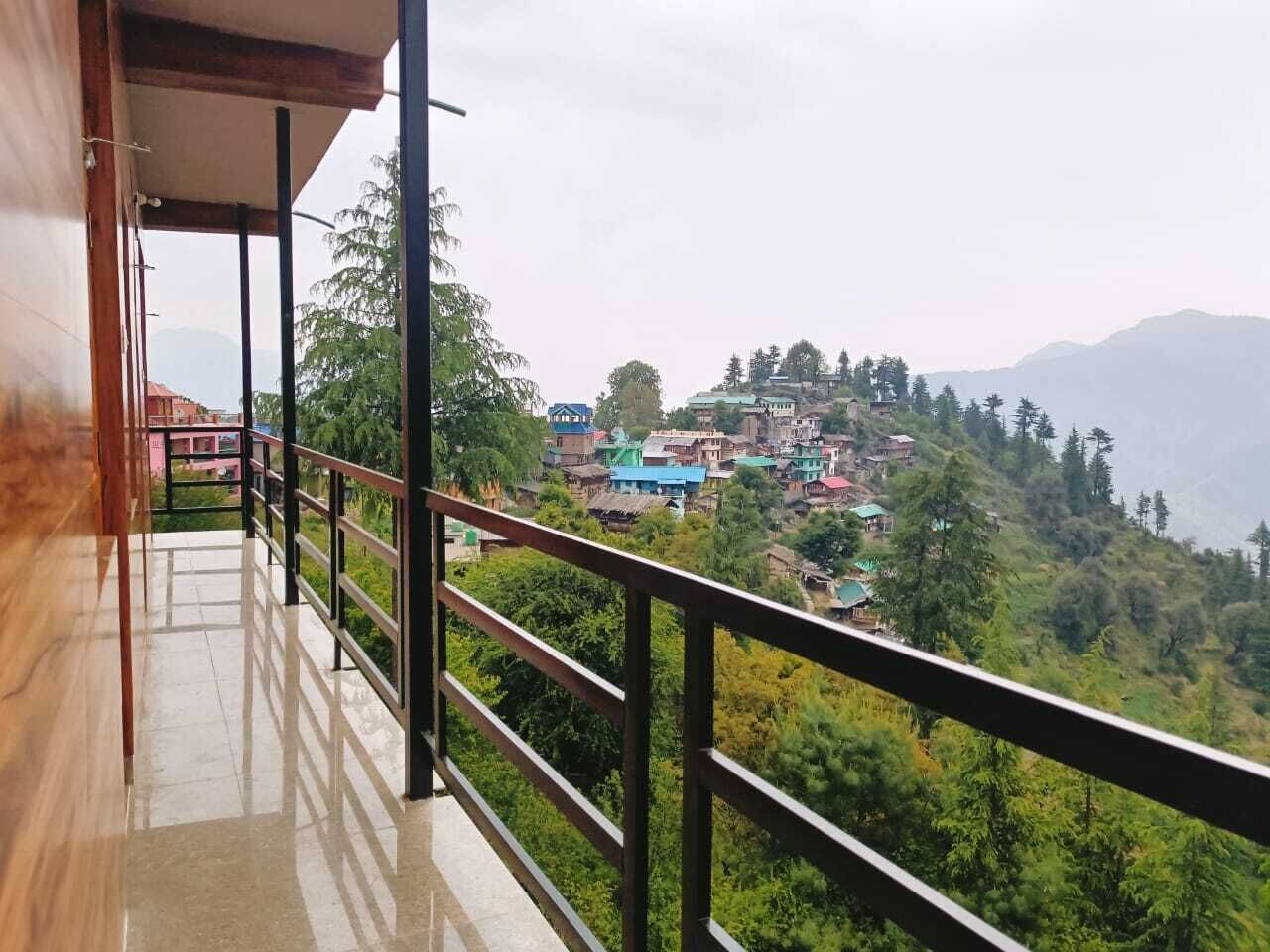 A balcony with a view of a hillside village.
