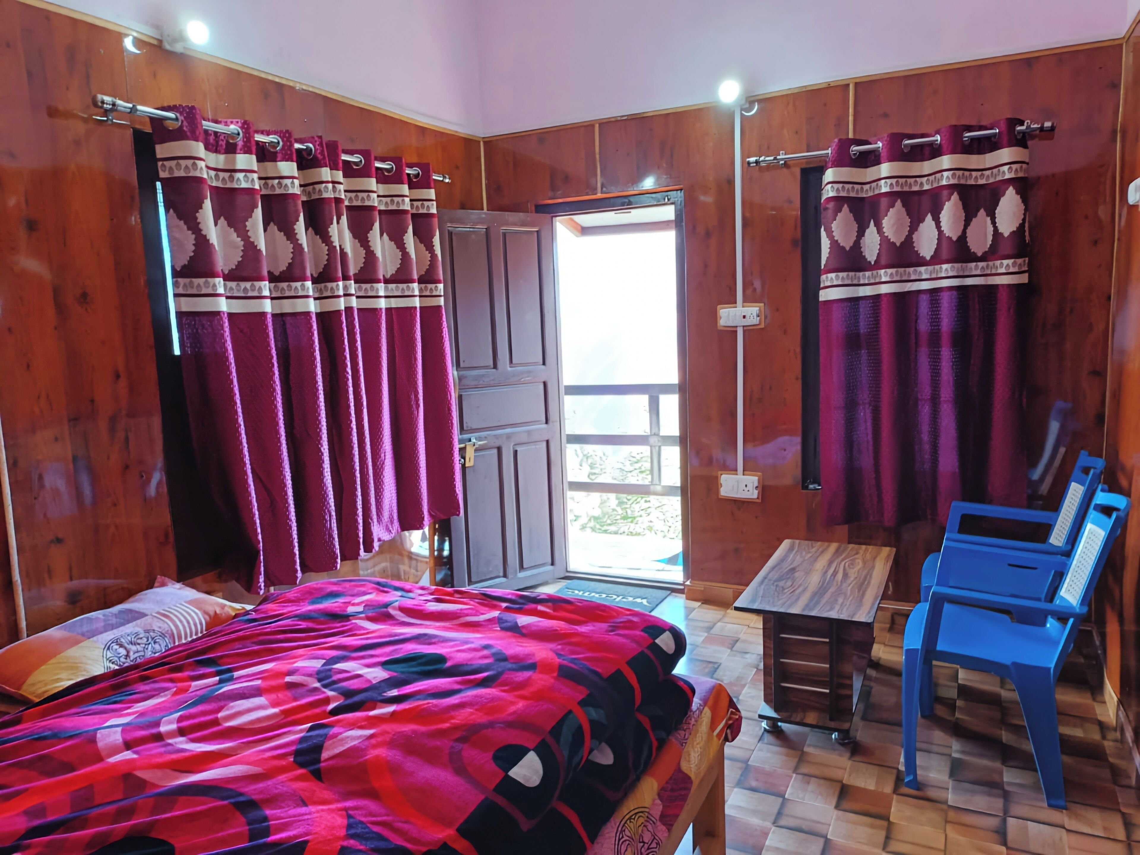 A room with a bed, a table, and two chairs.
