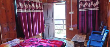 A room with a bed, a table, and two chairs.