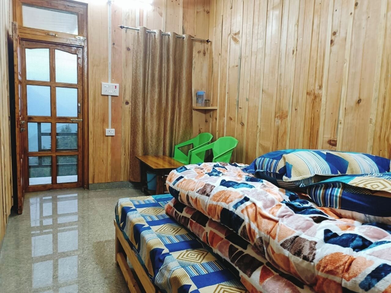 Una habitación de madera con una cama, una mesa y una silla.
