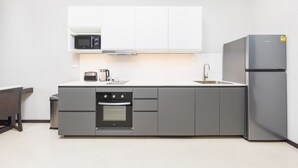 Cozinha compacta com micro-ondas, cafeteira e forno.