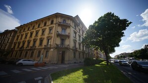 A multi-story building with classical architecture, a crosswalk, and parked cars. - Mantellate 9 (Florence)