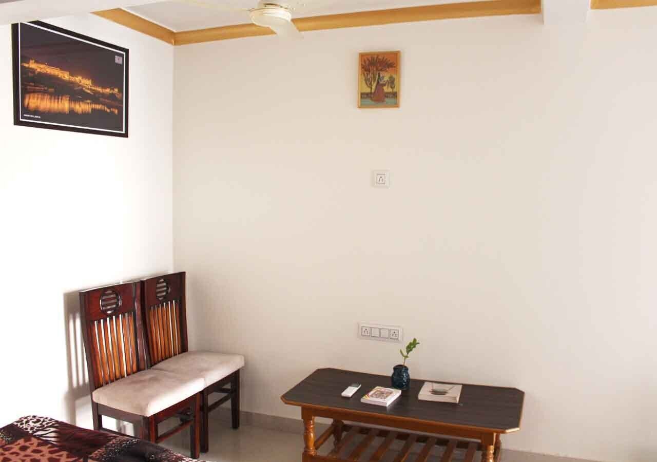 A room with a wooden dining table, a cushioned bench, and a framed picture on the wall.