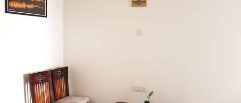 A room with a wooden dining table, a cushioned bench, and a framed picture on the wall.