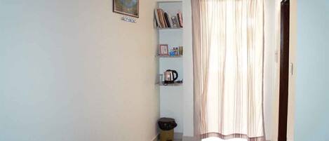 A hallway with a bookshelf, a radiator, and a door.