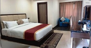 A hotel room with a bed, a sofa, a TV, and a bathroom area. - HOTEL RADIANCE PARK RAMPUR (Rampur)