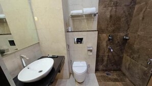 A bathroom with a white sink, toilet, and a shower area. - HOTEL RADIANCE PARK RAMPUR (Rampur)