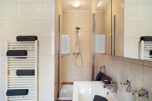 A bathroom with a shower, a sink, a mirror, and a towel rack. - Holiday Apartment 'Apart Annabell' with Mountain View, Private Terrace and Wi-Fi (Oetz)